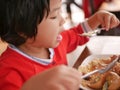 Little Asian baby girl eating white rice with pork and egg stewed in the gravy  Kai Pa Lo  by herself Royalty Free Stock Photo