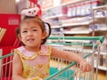 Little asian baby girl enjoy being in a shopping cart waiting for her mother to do shopping Royalty Free Stock Photo