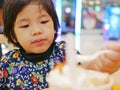 Little Asian baby girl enjoys having bread with ice cream by herself Royalty Free Stock Photo