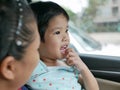 Little Asian baby girl having fun traveling with her mother by car as she learning to tell what she see during the trip Royalty Free Stock Photo