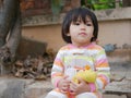 Little Asian baby girl sitting with a yellow duck doll Royalty Free Stock Photo