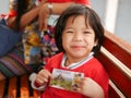 Little Asian baby girl very happy getting a ticket to visit a sightseeing with her mother