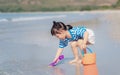 Little asian baby girl playing sand on the beach. Kid three years old play with sand toys Royalty Free Stock Photo