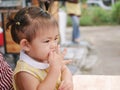 Little Asian baby girl putting her finger into her mouth Royalty Free Stock Photo