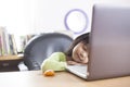 Little Asian baby girl sleeping on working desk with laptop Royalty Free Stock Photo