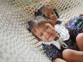 Little Asian baby girls the closer one enjoys lying down on a hammock with together with her older sister at home