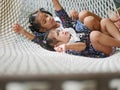 Little Asian baby girls the closer one enjoys lying down on a hammock with together with her older sister at home