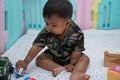 Little asian baby in Military uniform play toy Royalty Free Stock Photo