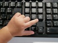 Little Asian baby`s finger pressing on a computer keyboard