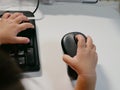 Little Asian baby`s hands on a computer mouse