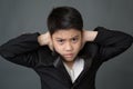 Little asian boy in black suit upset, depression face Royalty Free Stock Photo