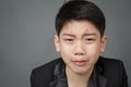 Little asian boy in black suit upset, depression face Royalty Free Stock Photo