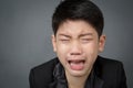 Little asian boy in black suit upset, depression face Royalty Free Stock Photo