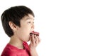 Little asian boy eating long cherry cake isolate on white background Royalty Free Stock Photo