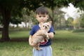 Little Asian boy happy with a Chihuahua dog in the park Royalty Free Stock Photo