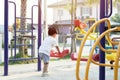 Little Asian boy having fun on a swing on the playground in public park on autumn day Royalty Free Stock Photo