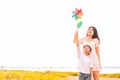 Little Asian boy and his mom playing colorful rainbow turbine in meadow. Mother and son playing together. Celebrating in Mother Royalty Free Stock Photo