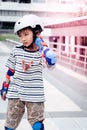 Little Asian Boy learning to Skate on an Rollerblade in park with full protection gear and helmet Royalty Free Stock Photo