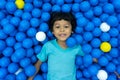 A little Asian boy is playing with a lot of blue and yellow balls Royalty Free Stock Photo