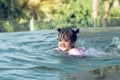 Little asian boy plays in the water while swimming in the pool wearing armbands Royalty Free Stock Photo