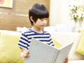 Little asian boy reading book at home Royalty Free Stock Photo