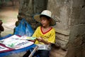 Little asian boy sitting with some souvenirs for sale