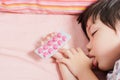 Little Asian Boy Sleep with Medicine panel in hand. Royalty Free Stock Photo