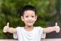 Little Asian boy success sign doing positive gesture with hand, thumbs up. Portrait of a smiling and happy little child showing Royalty Free Stock Photo