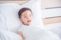 Boy waking up on bed and smiling at camera Royalty Free Stock Photo