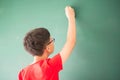 Little asian boy writing on empty green board school Royalty Free Stock Photo