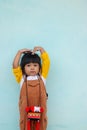Little asian child. Girls wearing brown bibs Raise your hands by touching the head. And stretched up Royalty Free Stock Photo