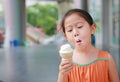 Little Asian child girl enjoy eating ice cream cone Royalty Free Stock Photo