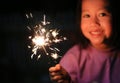 Little Asian child girl enjoy playing firecrackers. Focus at fire sparklers Royalty Free Stock Photo