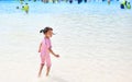 Little Asian child girl enjoys and running into big Swimming pool outdoor on holidays. Rear view children having fun Royalty Free Stock Photo