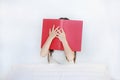 Little Asian child girl hiding face with open hardcover book sitting on bed with pillow Royalty Free Stock Photo