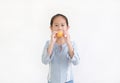 Little asian child girl hold and eating Custard Cake isolated on white background