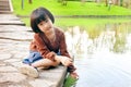 Little asian child playing on water from dock of lake Royalty Free Stock Photo