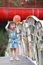 Aisa cute naughty lovely child girl play with balloon have fun outdoor in summer park happy smile happiness funny childhood Royalty Free Stock Photo