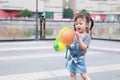 Aisa cute naughty lovely child girl play with balloon have fun outdoor in summer park happy smile happiness funny childhood Royalty Free Stock Photo