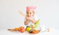 Little Asian girl action as cute and smile in front of vegetables and fruits on table with white background