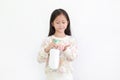 Little asian girl applying baby lotion in hands over white background. Kid press cream from bottle into her palm Royalty Free Stock Photo