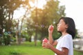 Little Asian girl blowing bubbles in the garden. Royalty Free Stock Photo