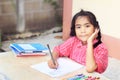 Little asian girl doing her homework at the table. Royalty Free Stock Photo