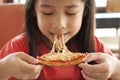 Little Asian girl enjoy pizza. Royalty Free Stock Photo