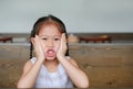 Little Asian girl with expression funny face lying on the wood table with looking at camera Royalty Free Stock Photo