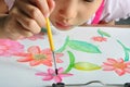 Little asian girl hand paint her watercolor picture