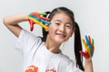 Little Asian girl with hands painted in colorful paints