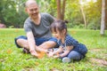 Little asian girl and her father looking at butterflies