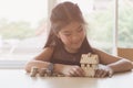 little asian girl hold little house with money stack - money saving education concept