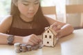 little asian girl hold little house with money stack - money saving education concept